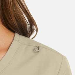A women's mock wrap top in a beige tone, featuring a decorative loop detail on the shoulder.