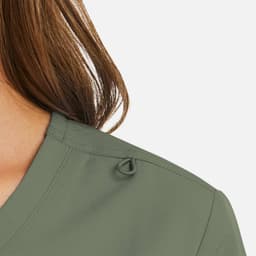 A mock wrap top in a soft green colour, featuring a loop detail at the shoulder and a v-neck design.