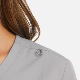 A grey mock wrap top with a subtle loop detail on the shoulder, showcasing soft fabric and neckline.