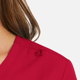 A red mock wrap top with a knot detail at the shoulder, featuring a smooth neckline and fabric texture.