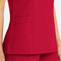 A close-up view of a women's mock wrap top in vibrant pink, featuring pockets and a sleek design.