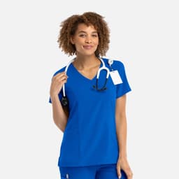 A woman wearing a vibrant blue mock wrap top, holding a stethoscope, featuring a logo on the design.