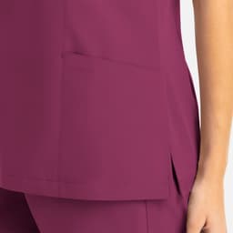 A magenta women's mock wrap top featuring a side pocket and a sleek design. The fabric has a smooth finish.