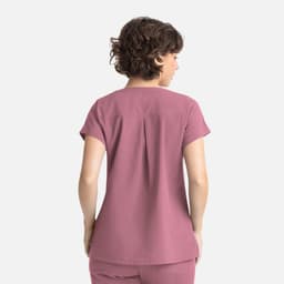 A women's top in a soft mauve colour with short sleeves and a pleat detail at the back. Features a logo.