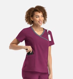 A women's mock wrap top in burgundy with contrast trim and pockets, featuring a logo.
