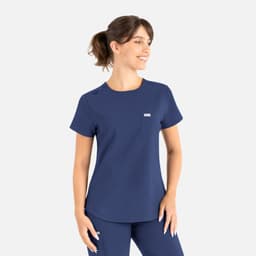 A navy blue round neck top designed as part of scrubs, featuring a pocket and a brand logo.