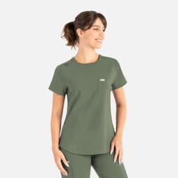 A green round neck scrub top with a pocket and a logo, worn by a smiling model.