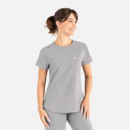 A grey round neck top with a pocket and shoulder detail, designed as a uniform scrub top.