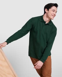 A green long-sleeve polo shirt displayed on a smiling model, paired with brown trousers. It features a logo.