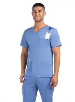 A man wearing a blue V-neck top with three pockets, featuring a logo and a tag.