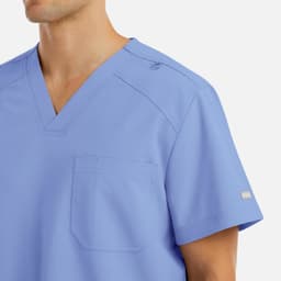 A men's tuckable v-neck top in light blue, featuring a pocket and a logo on the sleeve.