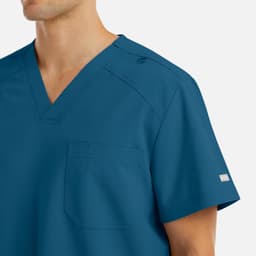 A men's v-neck top in a vibrant blue colour, featuring a pocket and a logo on the sleeve.
