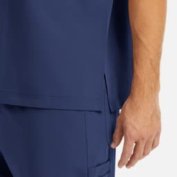A navy men's tuckable V-neck top featuring a side slit and a hand resting near the bottom hem.