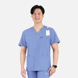 A blue men's V-neck top featuring four pockets and a logo, worn by a smiling model.