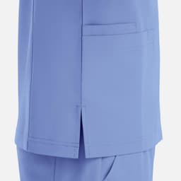 A light blue v-neck top featuring four pockets and side slits for added comfort. Includes a logo.
