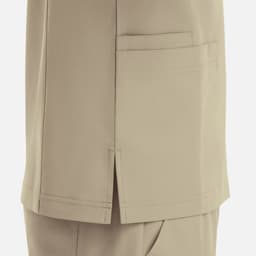 A beige V-neck top featuring four pockets, with a side slit detail and a logo present.
