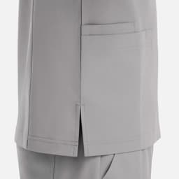 A grey V-neck top featuring four pockets and a side split, designed for ease and comfort. It has a branding logo.