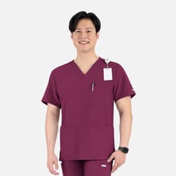 A men's v-neck top in maroon featuring four pockets and a logo, worn by a smiling model.