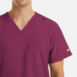 A maroon V-neck top with four pockets and a logo on the shoulder. Features a plain design suitable for various settings.