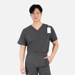 A grey men's v-neck top featuring a contrasting piping detail and a pocket. It includes a tag and has a minimalist design.