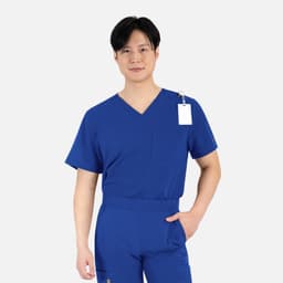 A man wears a royal blue V-neck top with a pocket and a tag, featuring a comfortable fit.