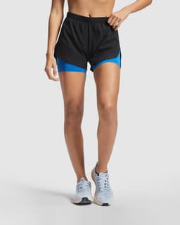 Black running shorts featuring blue under-shorts, with an elastic waistband and side panels. The model is wearing running shoes.