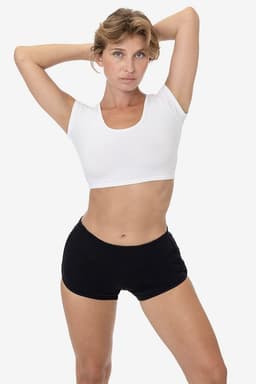 A model wears black interlock running shorts paired with a white crop top, showcasing a sleek athletic look.