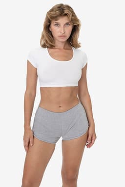A model wearing grey interlock running shorts paired with a white crop top, showcasing a fitted design and casual style.