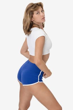 A pair of blue interlock running shorts with white trim, displayed on a model in a cropped white top.