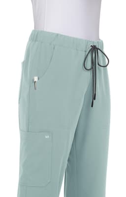 Light green pants with an elastic waistband, side pockets, and a drawstring detail. The product includes a logo.