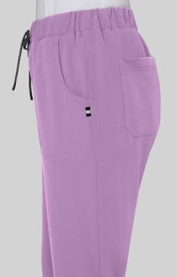 A pair of lilac pants with an elastic waistband, side pockets, and a small logo.