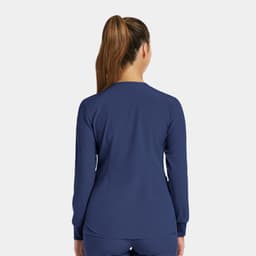 A women's round neck snap jacket in navy, featuring long sleeves and a fitted style. Includes a logo on the back.