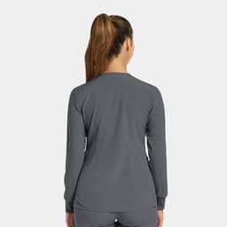 A women's round neck snap jacket in grey, featuring long sleeves and a plain design with a logo.