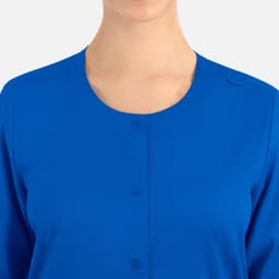 A women's round neck snap jacket in vibrant blue with a button detail at the collar.