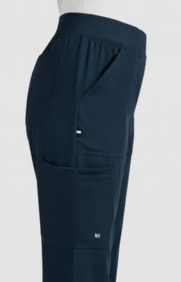 A side view of navy boot cut pants featuring pockets and a logo on the leg.