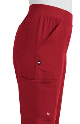 A pair of red boot cut pants with pockets displayed from the side, featuring a small logo.