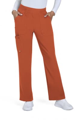 An orange boot cut pant with pockets, styled with a white top and paired with white shoes.
