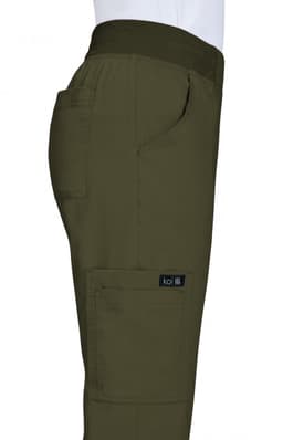 A pair of olive green pants with side pockets and a logo, displayed from the side.