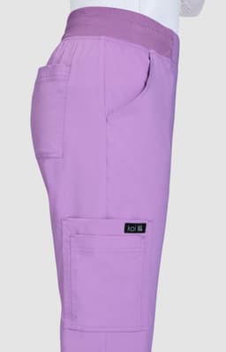 A pair of lilac pants featuring pockets and an elastic waistband, with a branding label on the side.