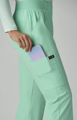 A mint green pant with a pocket, holding a phone, featuring a small logo on the side.