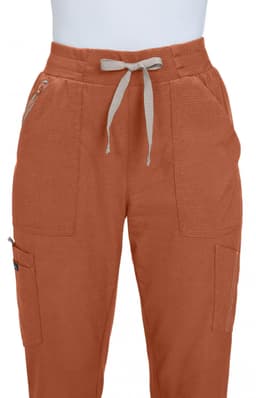 An orange pair of jogger pants featuring two front pockets and a drawstring waistband. It has a branding logo on one pocket.