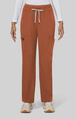 A pair of wide-leg pants in burnt orange, featuring pockets and a drawstring waist. The model is wearing a white long-sleeve top.