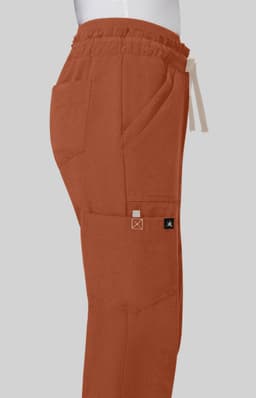 Freda Wide Leg Pant in earthy orange with an elastic waistband and side pockets displayed against a grey background.