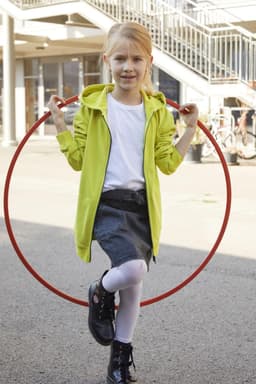 A children's zip hoodie in vibrant lime green, worn by a girl holding a red hula hoop, set outdoors.
