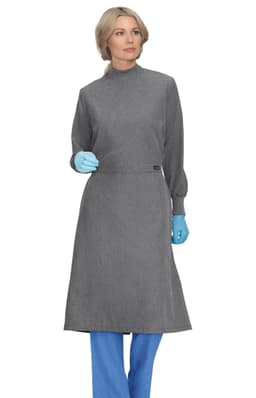 A clinical cover gown in grey, worn by a model with blue gloves and blue pants. The gown has long sleeves and a high collar.