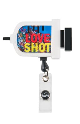 A white shaker badge features colourful gemstones and a branding logo, with a clip for attachment.