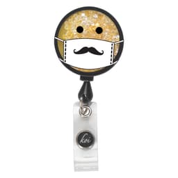 A round badge featuring a yellow, glittery design with a mask and a moustache, attached to a retractable clip.