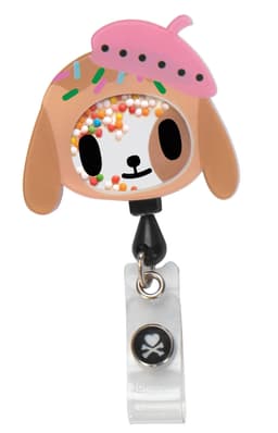 A colourful tokidoki Shaker Badge featuring a dog character with sprinkles and a pink hat, attached to a clear clip.