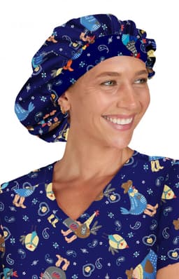 A bouffant scrub cap in navy blue featuring colourful designs, worn by a smiling individual in matching scrubs.