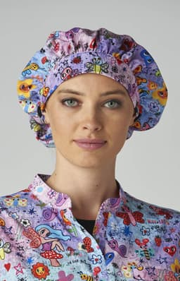 A bouffant cap in pink, featuring a colourful print of flowers and butterflies, worn by a woman.